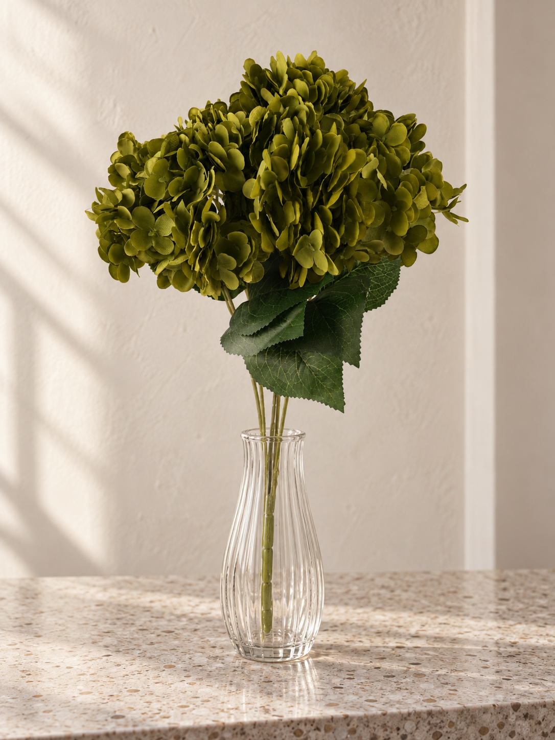 T&CO luxury artificial olive green hydrangea stem 68cm displayed in glass cylinder vase