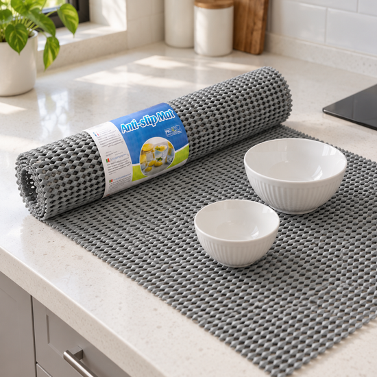 T&CO cushioned mesh anti-slip drawer and shelf grip mat roll 45x150cm in grey unrolled on kitchen counter with white bowls