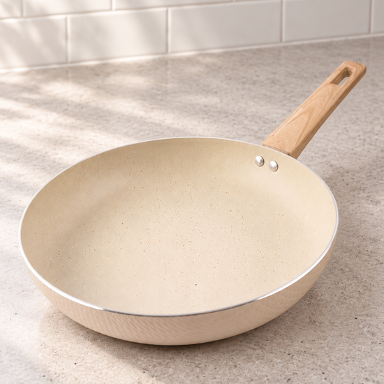 T&CO 28cm hammered ceramic non-stick frying pan skillet in cream peach with wood-grain stay-cool handle on kitchen counter