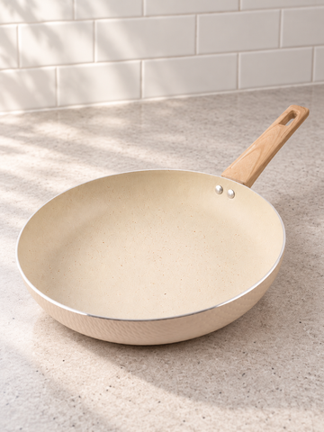 T&CO 28cm hammered ceramic non-stick frying pan skillet in cream peach with wood-grain stay-cool handle on kitchen counter