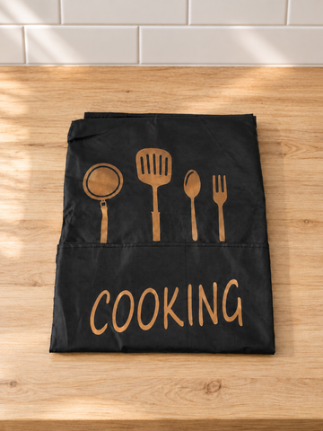 Fresh waterproof black kitchen apron with large front pocket, golden utensil print, and COOKING script