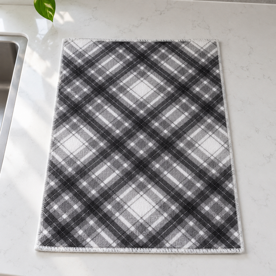 Fresh ultra-absorbent grey and white diagonal plaid microfiber dish drying mat with reinforced stitched border on countertop