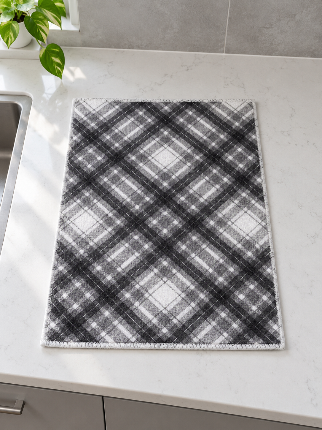 Fresh ultra-absorbent grey and white diagonal plaid microfiber dish drying mat with reinforced stitched border on countertop