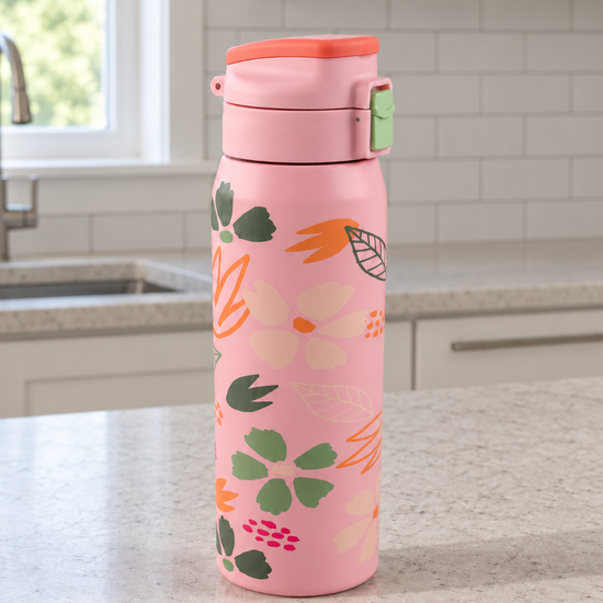 T&CO coral pink vacuum insulated flask featuring botanical floral petal motif with push-button flip lid and safety lock