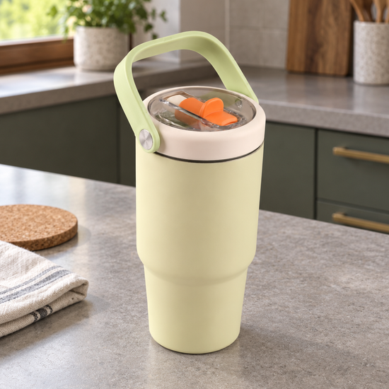 T&CO pastel lemon chiffon yellow vacuum insulated travel tumbler with green swing carry handle and clear lid with orange sipper