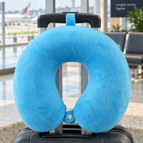 T&CO ultra-soft solid plush travel neck pillow in sky blue with top hanging loop and front snap button strap