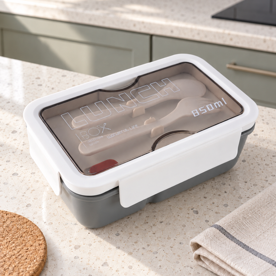 T&CO 850ml bento lunch box in sleek slate grey with white clip lock lid and transparent smoked compartment containing reusable fork and spoon