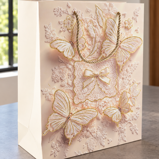 Medium blush pink butterfly bow lace gift bag with gold glitter wings and rope handles