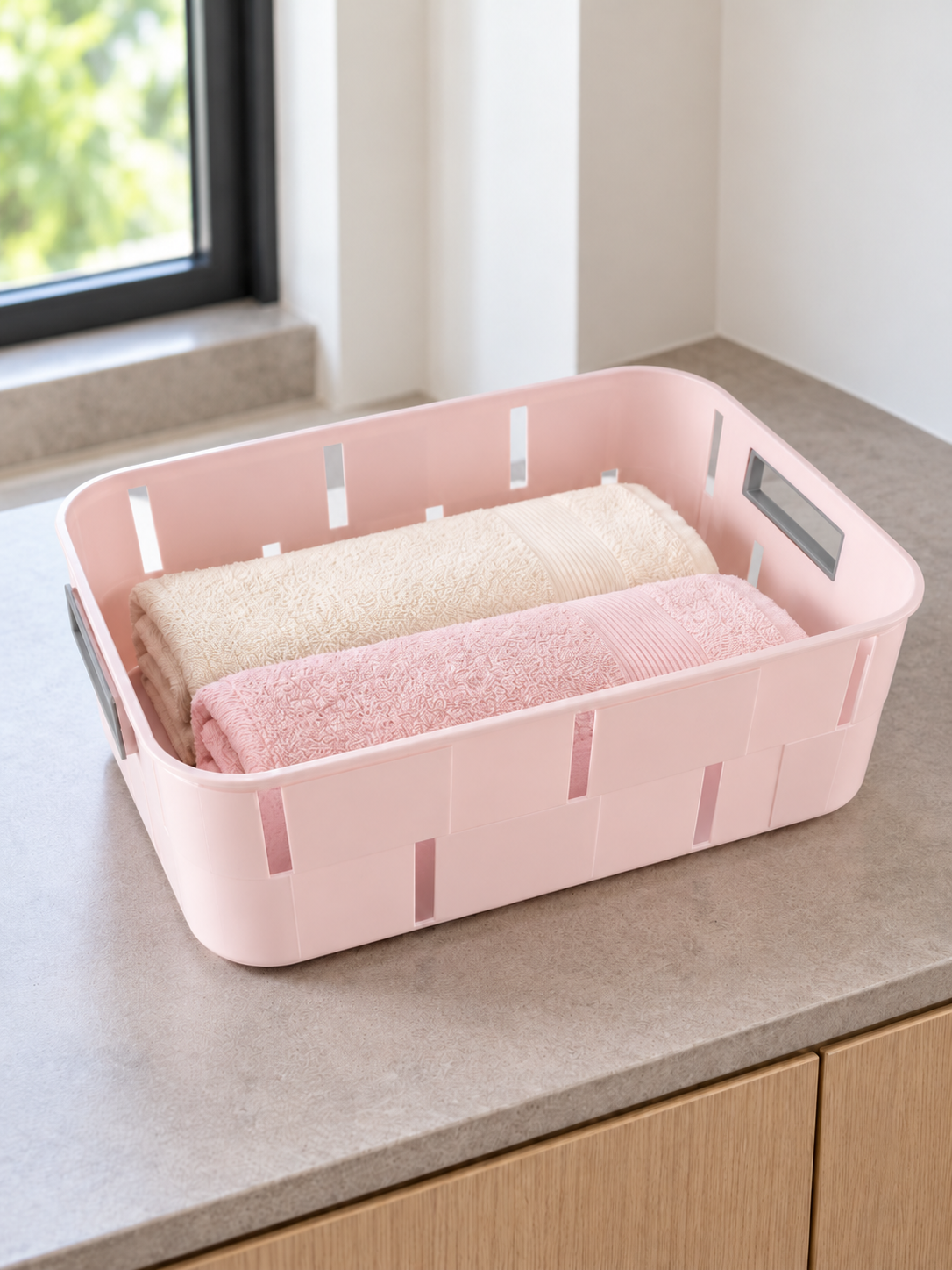 Pastel pink plastic storage tub basket with cutout side handles for home organization