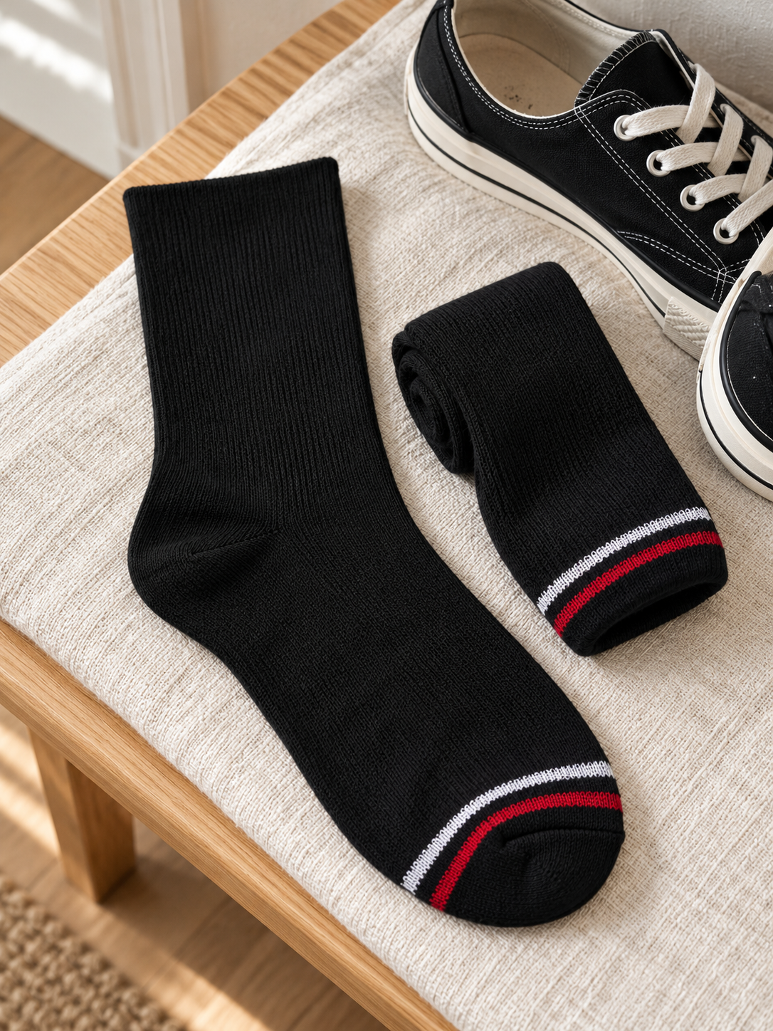 Men's athletic ribbed cotton crew socks in solid jet black with sporty red and white toe stripe accent resting beside casual canvas sneakers