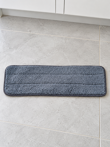 Grey rectangular microfiber replacement mop cleaning pad measuring 40 by 12 cm on ceramic tile floor