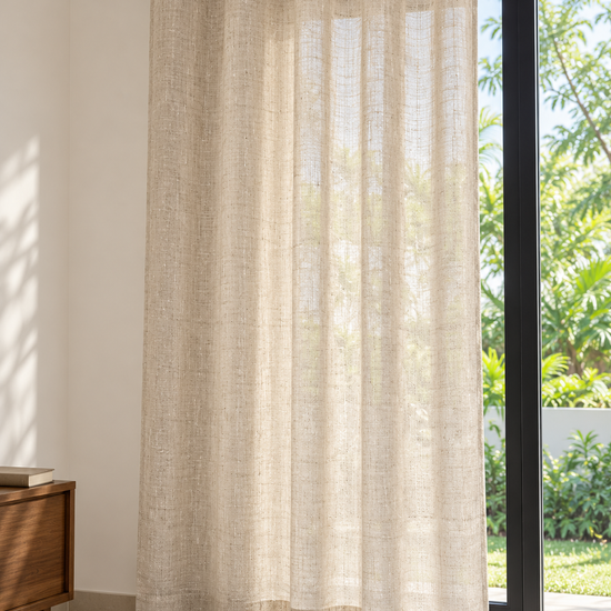 Natural flax open weave semi sheer eyelet curtain panel hung beside sliding glass patio door