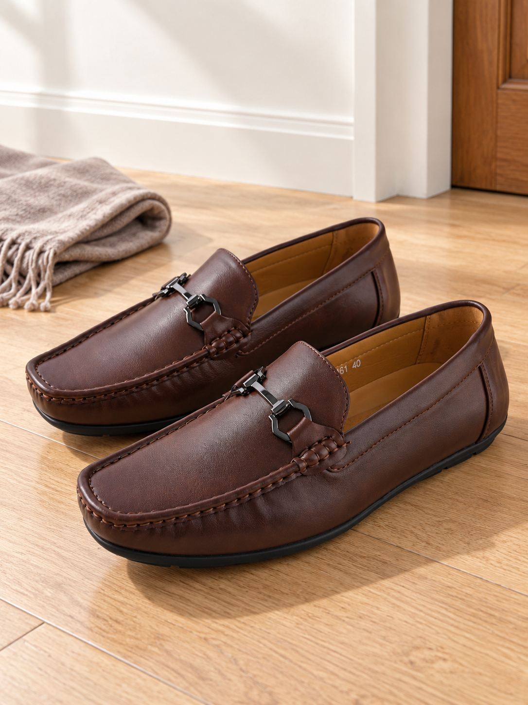 Men's rich brown faux leather horsebit driving loafers with gold-toned metal buckle hardware and textured driving outsole