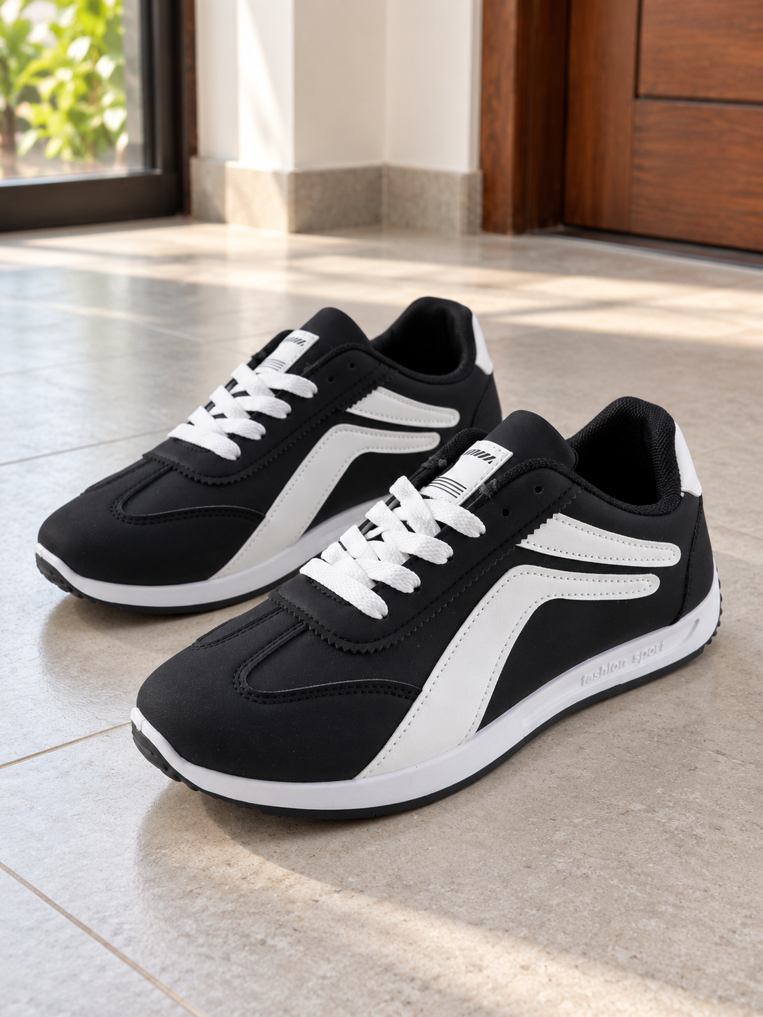Men's black and white low-top fashion sport casual sneakers with white curved side stripes, white laces, and lightweight white foam sole