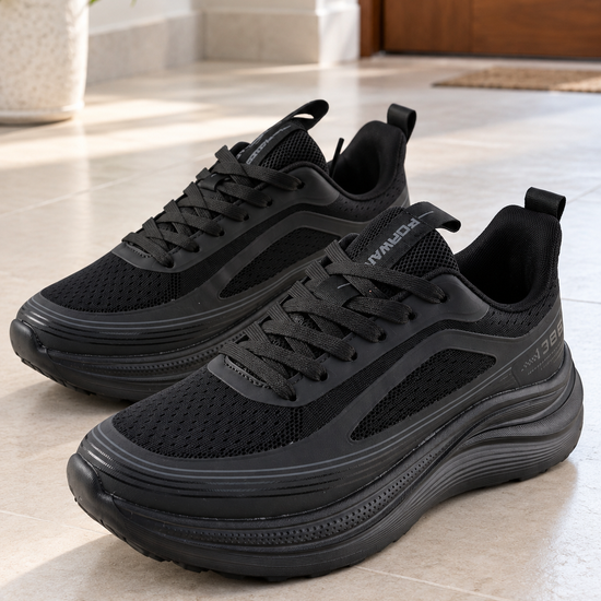 Men's all-black max-cushion rocker-sole athletic running sneakers with thick curved foam midsole, forward tongue tab, and breathable mesh upper