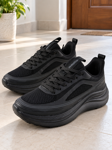 Men's all-black max-cushion rocker-sole athletic running sneakers with thick curved foam midsole, forward tongue tab, and breathable mesh upper