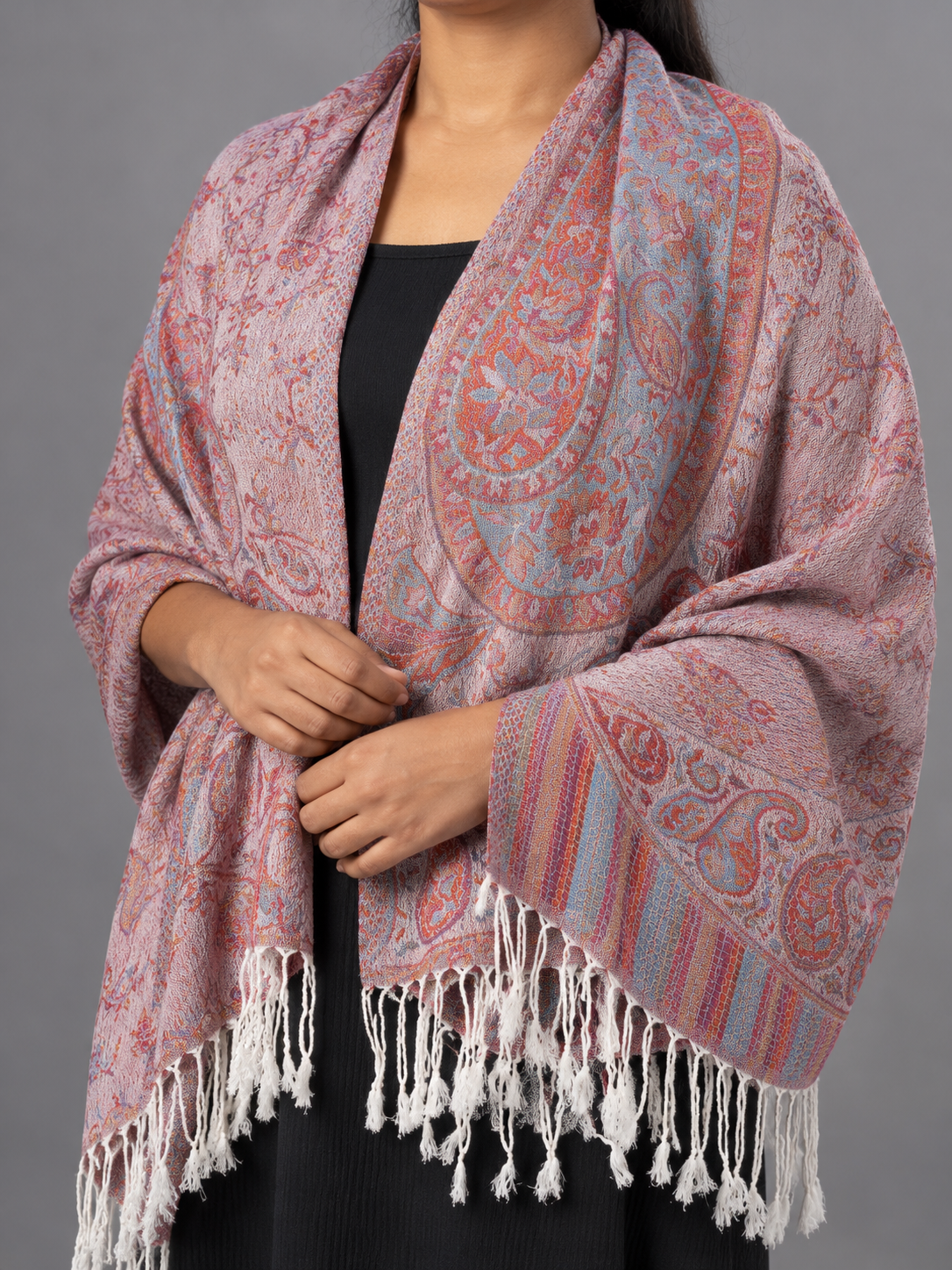Women's dusty rose pink and slate teal blue jacquard woven pashmina wrap featuring paisley floral medallions, striped border, and white twisted fringe hem