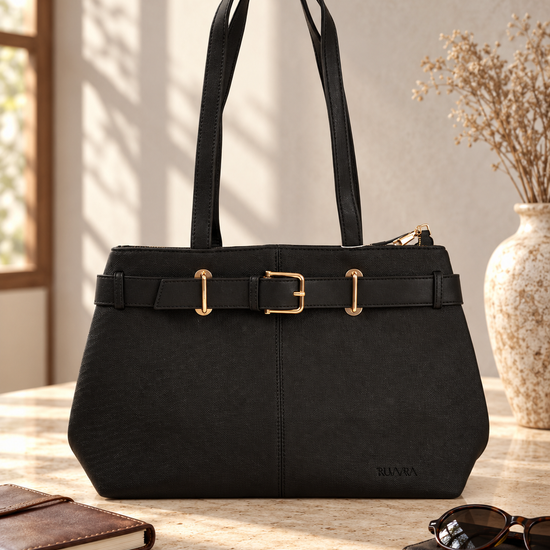 Nuvaara women's belted black grained vegan leather shoulder tote bag featuring front belt detail with polished gold buckle and tall shoulder handles
