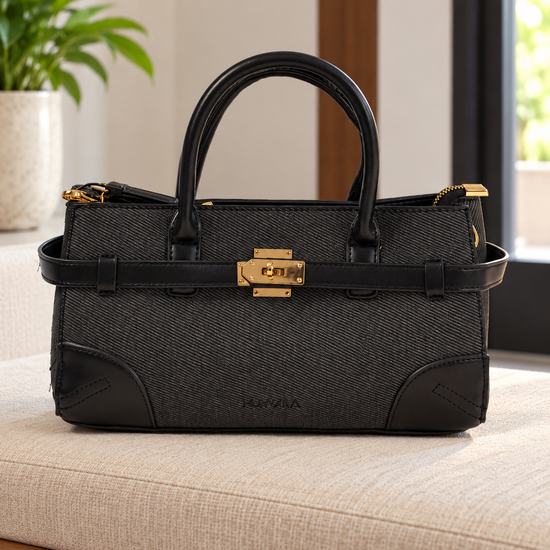 Nuvaara women's East-West structured black twill satchel handbag with smooth vegan leather trim, front belt strap, and gold turn-lock plate