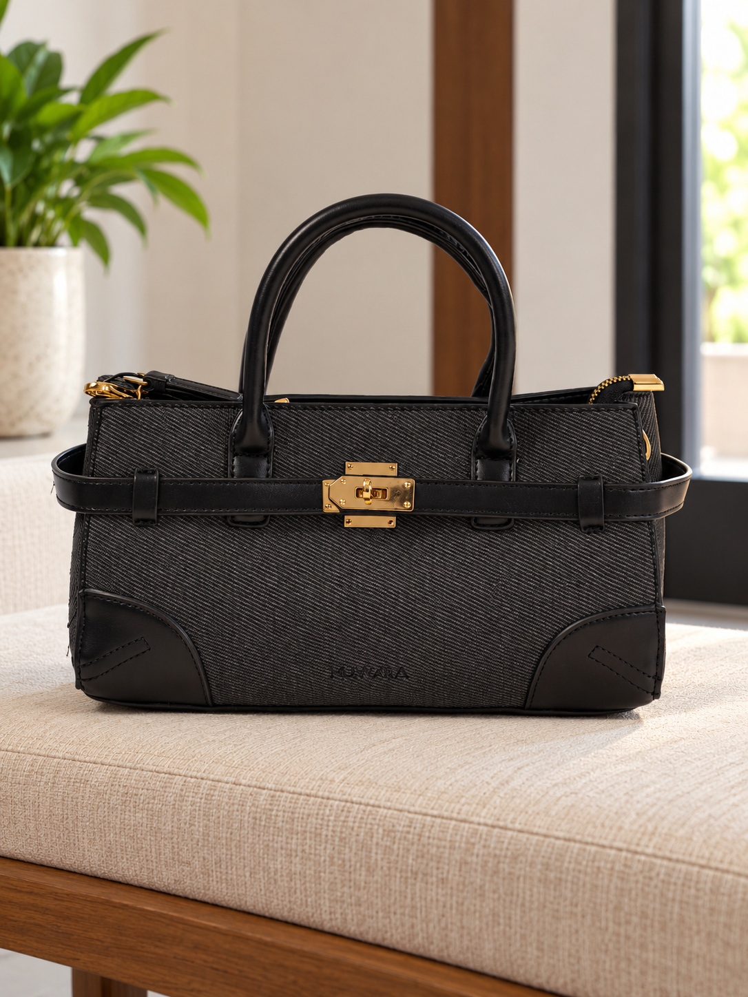 Nuvaara women's East-West structured black twill satchel handbag with smooth vegan leather trim, front belt strap, and gold turn-lock plate