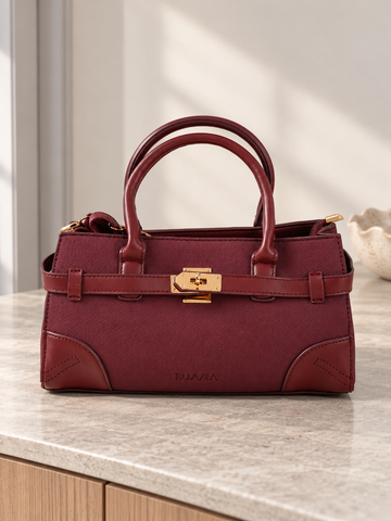 Nuvaara women's East-West structured wine burgundy twill satchel handbag with smooth vegan leather trim, front belt strap, and gold turn-lock plate