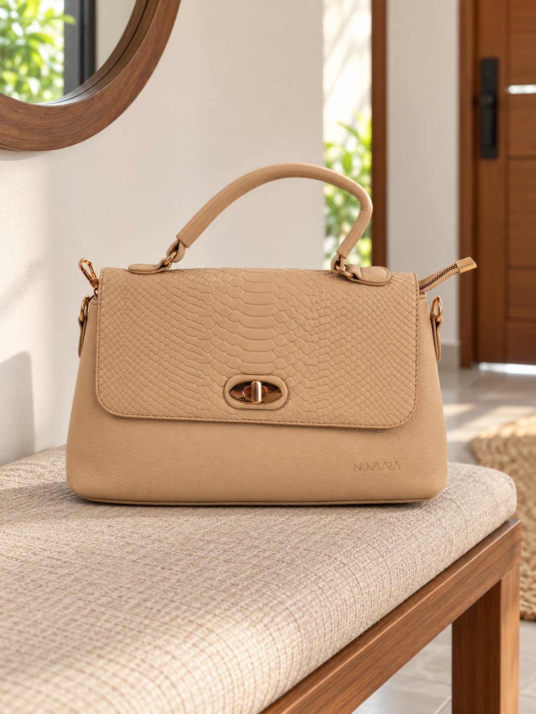 Nuvaara women's structured soft beige shoulder bag featuring snake-embossed front flap, gold oval turn-lock clasp, arched top handle, and crossbody strap