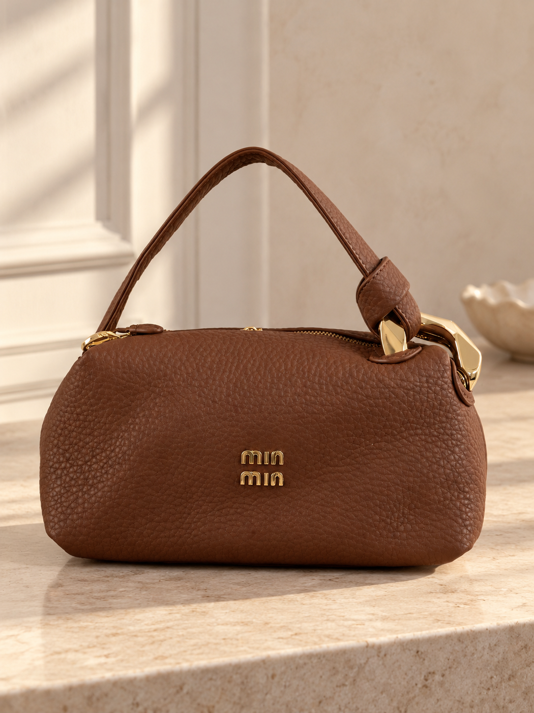 Nuvaara women's rich brown pebbled vegan leather shoulder handbag featuring an asymmetric knotted handle accented with chunky polished gold-tone metal chain link