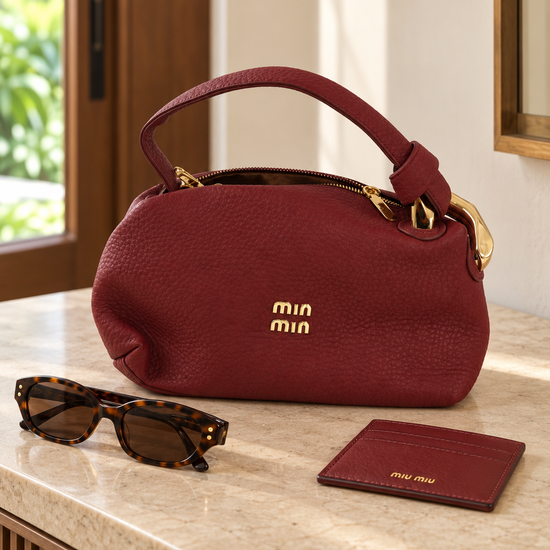 Nuvaara women's wine burgundy pebbled vegan leather shoulder handbag featuring an asymmetric knotted handle accented with chunky polished gold-tone metal chain link