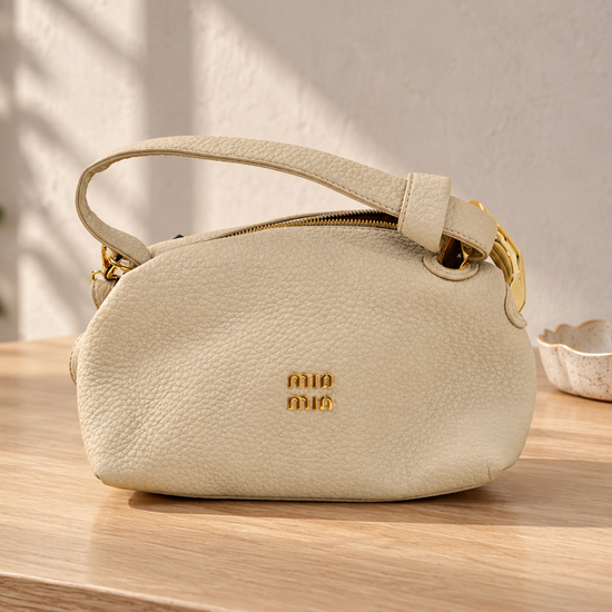 Nuvaara women's ivory off-white pebbled vegan leather shoulder handbag featuring an asymmetric knotted handle accented with chunky polished gold-tone metal chain link