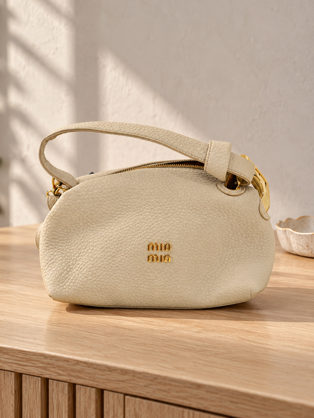 Nuvaara women's ivory off-white pebbled vegan leather shoulder handbag featuring an asymmetric knotted handle accented with chunky polished gold-tone metal chain link