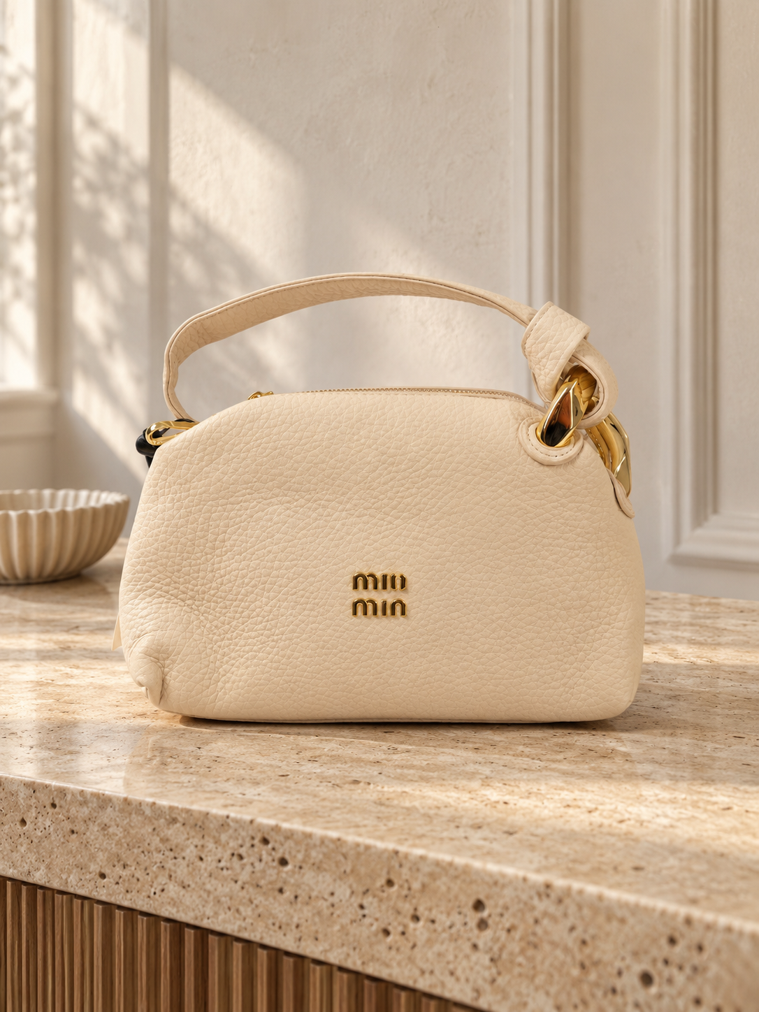 Nuvaara women's soft cream pebbled vegan leather shoulder handbag featuring an asymmetric knotted handle accented with chunky polished gold-tone metal chain link