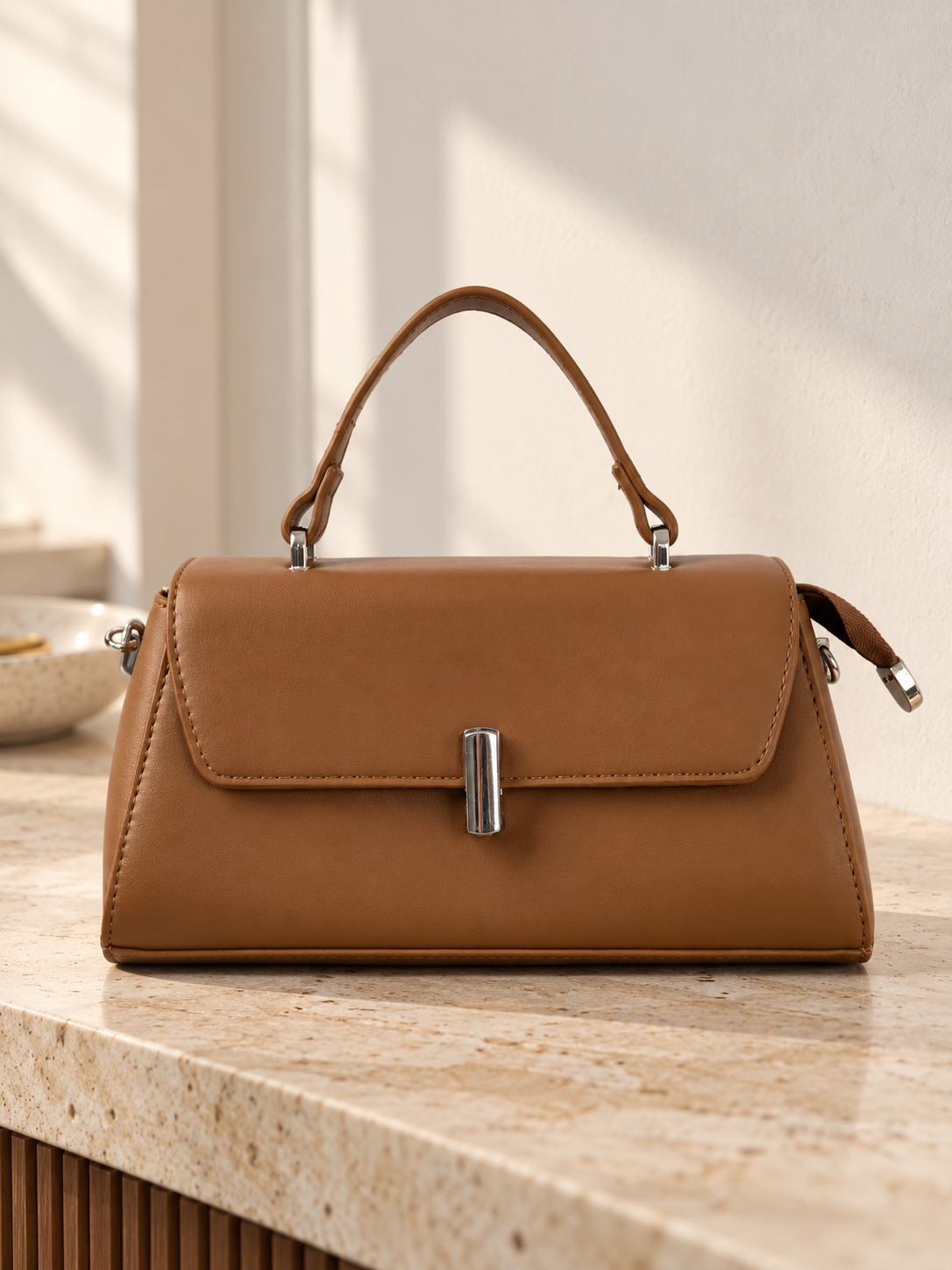 Nuvaara women's structured cognac brown vegan leather top-handle handbag featuring a sleek front flap and vertical cylindrical silver-tone turn-lock clasp