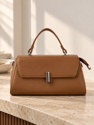 Nuvaara women's structured cognac brown vegan leather top-handle handbag featuring a sleek front flap and vertical cylindrical silver-tone turn-lock clasp