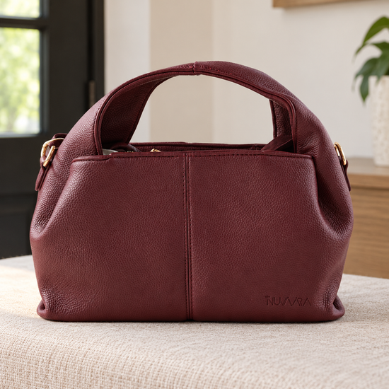 Nuvaara women's wine burgundy pebbled vegan leather slouchy curved dome satchel handbag with center vertical seam, dual arched handles, and debossed logo