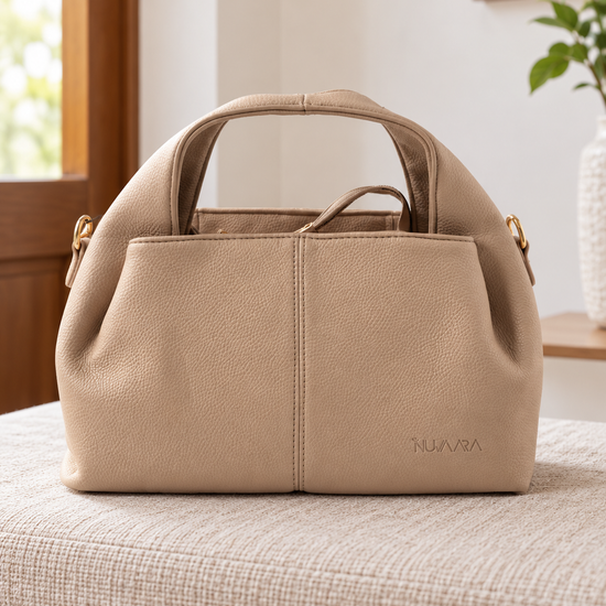 Nuvaara women's warm taupe pebbled vegan leather slouchy curved dome satchel handbag with center vertical seam, dual arched handles, and debossed logo