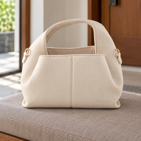 Nuvaara women's soft cream pebbled vegan leather slouchy curved dome satchel handbag with center vertical seam, dual arched handles, and debossed logo