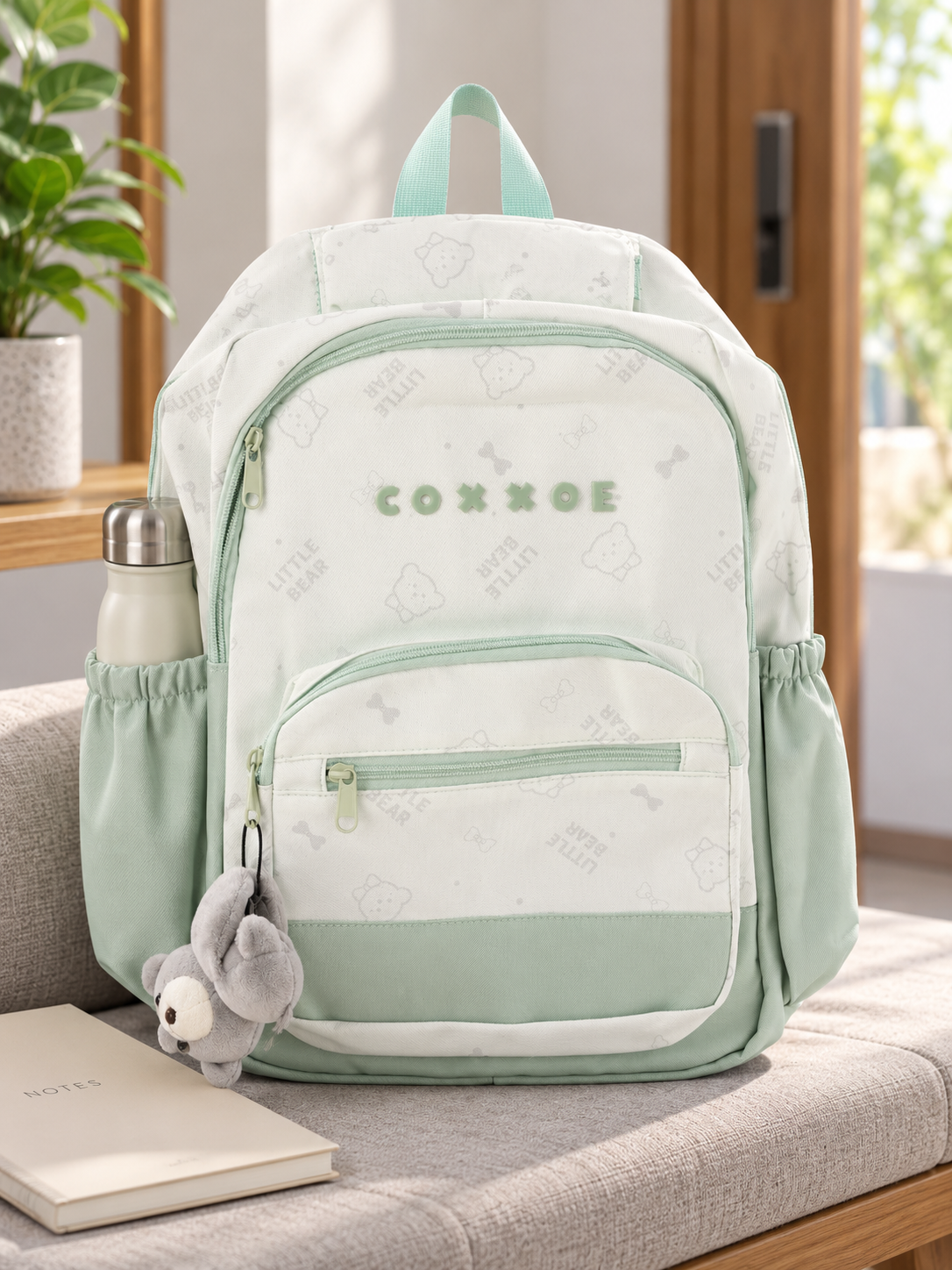 Thilakma Little Bear printed pastel mint green nylon school backpack with white teddy bear motifs, front organizer pocket, and hanging plush bear charm keychain