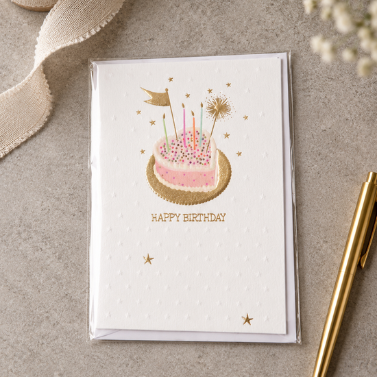 Embossed Happy Birthday card with heart-shaped birthday cake on a gold foil platter with candles and sparkler