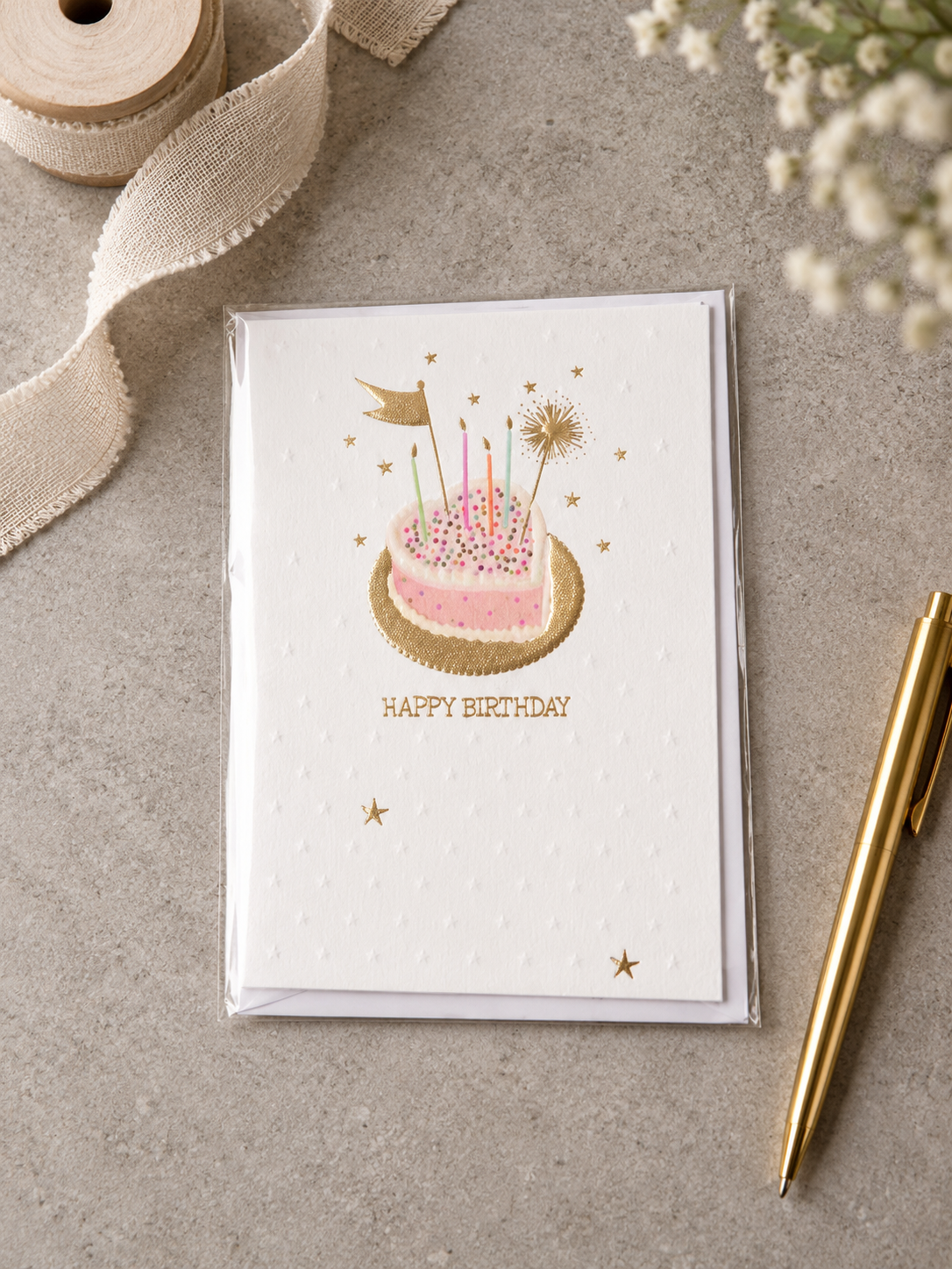 Embossed Happy Birthday card with heart-shaped birthday cake on a gold foil platter with candles and sparkler