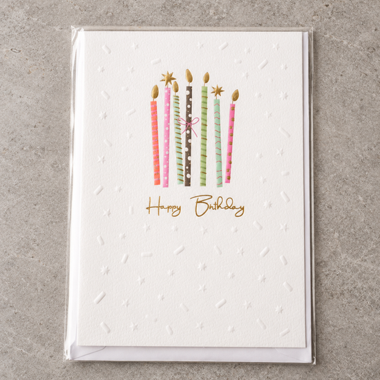 Embossed Happy Birthday greeting card featuring colourful patterned birthday candles tied with a pink bow and gold foil flames