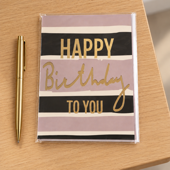Modern mauve, black, and peach striped Happy Birthday greeting card with shimmering gold foil lettering and matching envelope