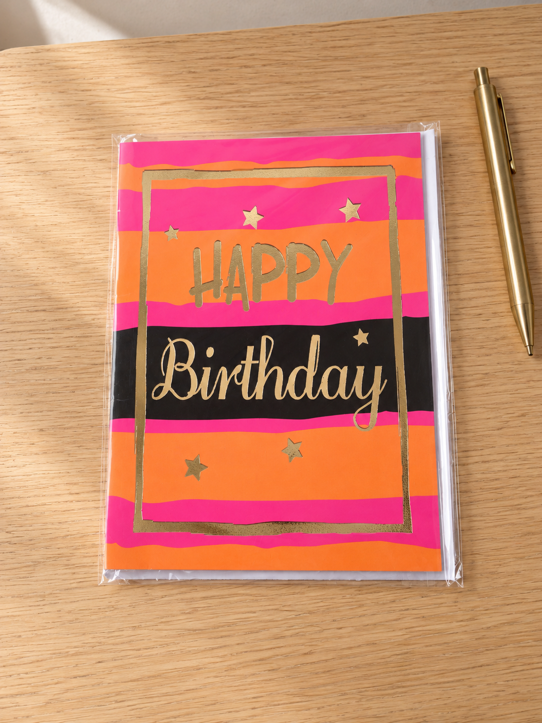 Vibrant sunset pink and orange striped Happy Birthday greeting card with shining gold foil border and lettering