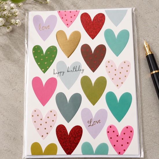 Colorful patterned hearts birthday greeting card with sparkling red glitter and gold foil accents reading happy birthday