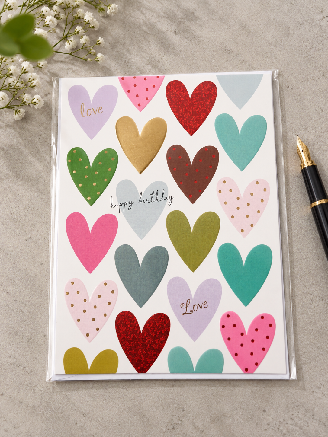 Colorful patterned hearts birthday greeting card with sparkling red glitter and gold foil accents reading happy birthday