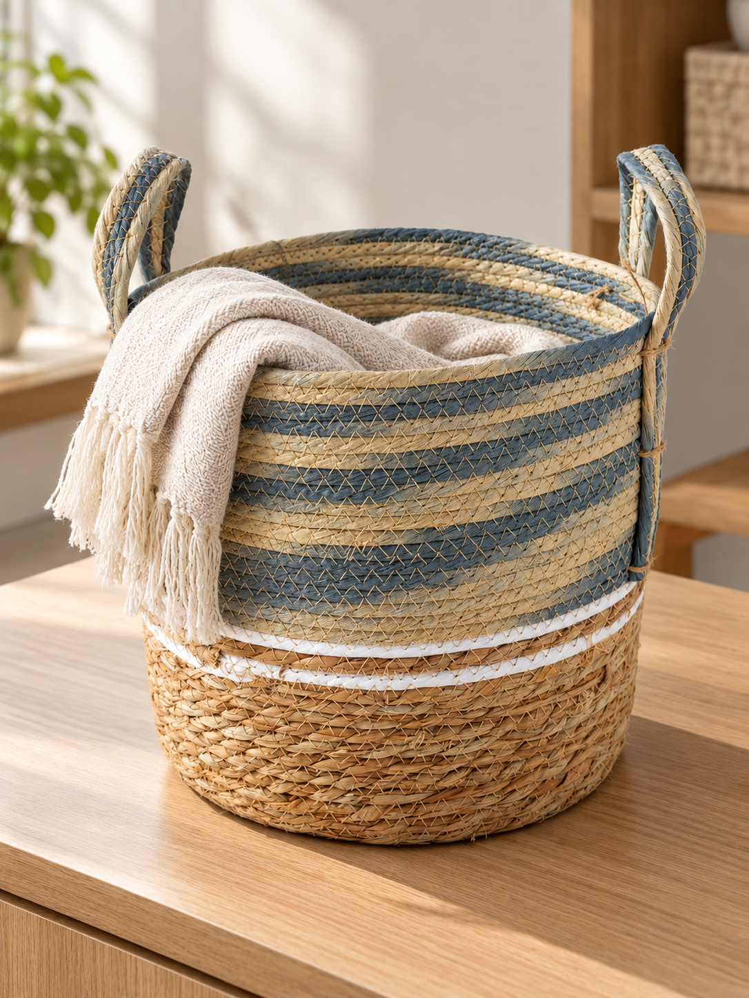 Medium blue and beige two-tone handwoven seagrass storage basket with braided handles