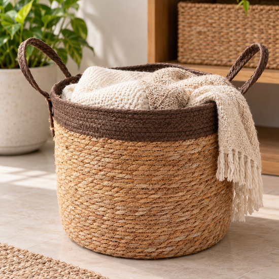 Large natural woven straw storage basket featuring a thick brown rim border and braided loop handles