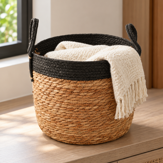 Medium natural woven straw storage basket with black braided top rim and dual carrying handles