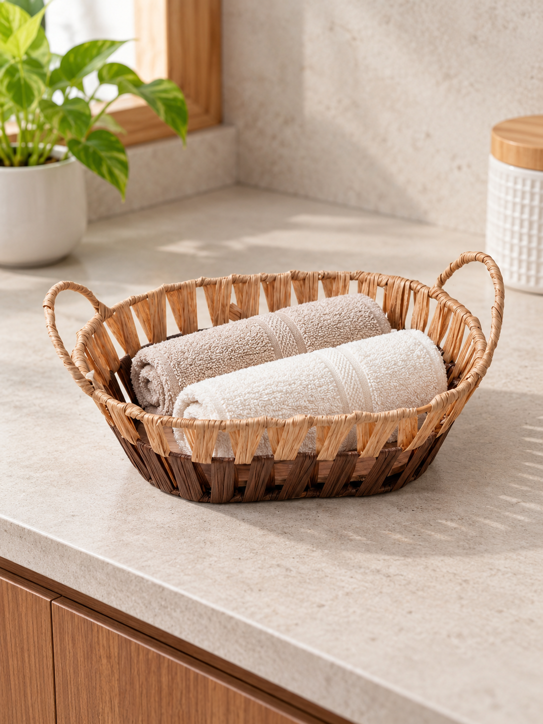 Small shallow oval woven storage basket tray with walnut brown base, natural rim, and built-in handles