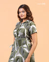 Front view of model posing with hand in pocket wearing Cinnamon Isle olive geometric shirt dress