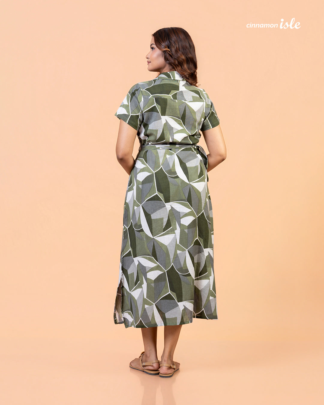 Full shot of model wearing Cinnamon Isle olive green geometric belted shirt dress